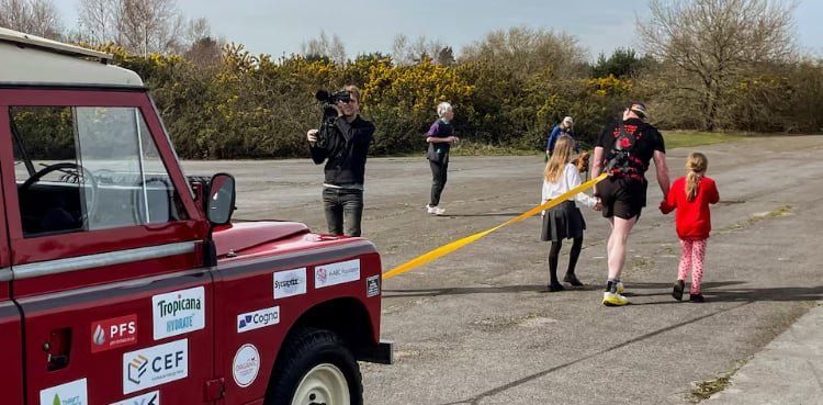 Former UK soldier units off for 100 km charity stroll, pulling a Land Rover